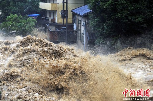 6月14日,福建南平西芹镇,山洪肆虐,涌向民房。这二日延平区降特大暴雨,强降雨导致延平、顺昌等地多处出现山体滑坡、泥石流等地质灾害。中新社发 柳涛 摄